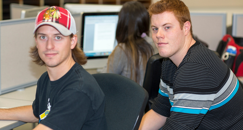 picture of two centennial college journalism students in the journalism lab